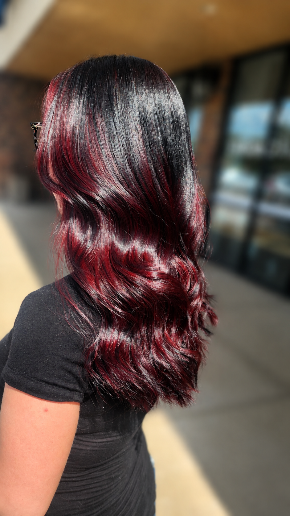 Black hair with deep crimson and burgundy color melt, voluminous waves